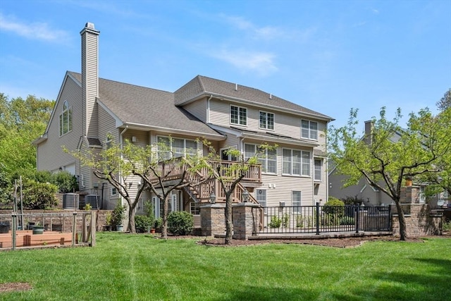 rear view of house featuring a chimney, a wooden deck, stairway, and a vegetable garden