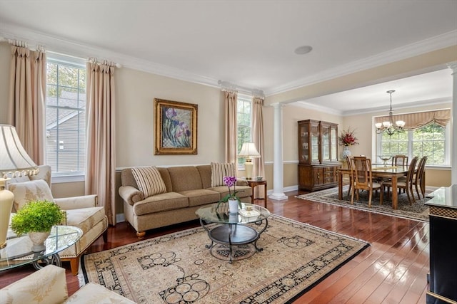 living area featuring ornate columns, dark wood-style floors, baseboards, a chandelier, and crown molding