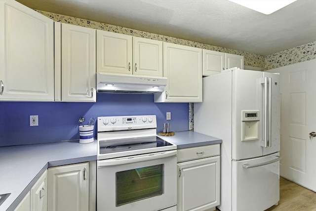 1 New Castle Rd, Ashland, MA 01721 - kitchen with white appliances, under cabinet range hood, light countertops, white cabinets, and light wood-style flooring