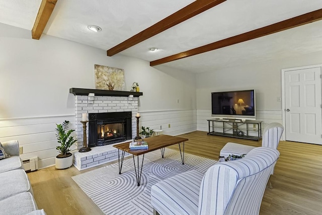 1 New Castle Rd, Ashland, MA 01721 - living room featuring beamed ceiling, wood finished floors, a fireplace, wainscoting, and a baseboard radiator