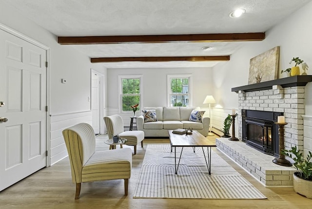 1 New Castle Rd, Ashland, MA 01721 - living area featuring wood finished floors, wainscoting, beamed ceiling, a fireplace, and a baseboard heating unit