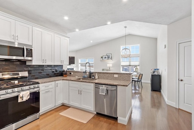 kitchen featuring white cabinetry, appliances with stainless steel finishes, vaulted ceiling, and sink