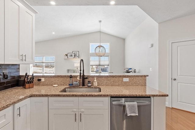 kitchen featuring white cabinetry, lofted ceiling, dishwasher, and sink