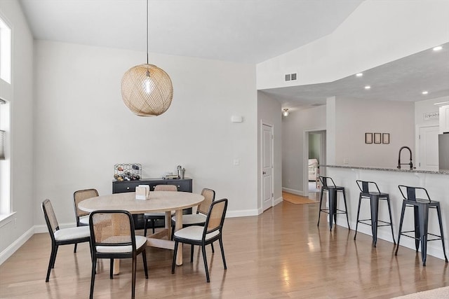 dining space with sink and light hardwood / wood-style flooring