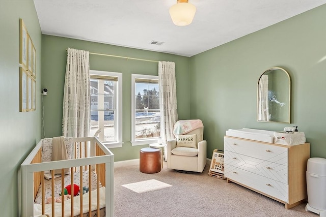 carpeted bedroom featuring a nursery area