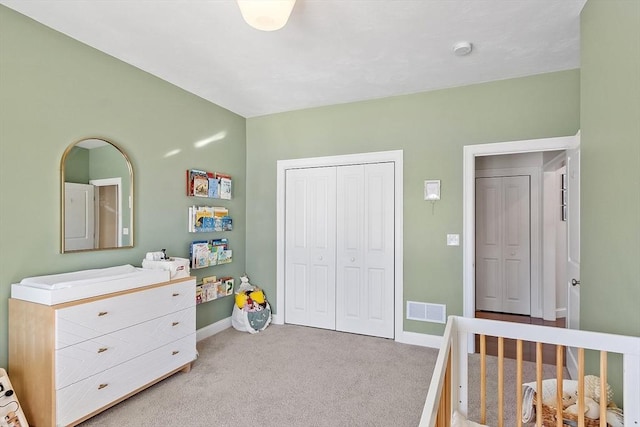 carpeted bedroom featuring a closet and a nursery area