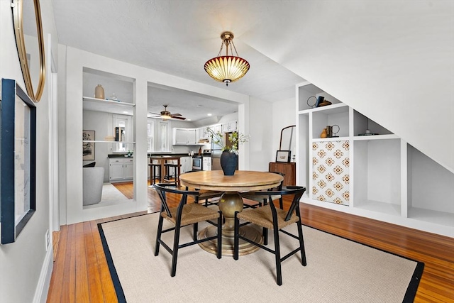 dining space featuring built in features and light hardwood / wood-style floors