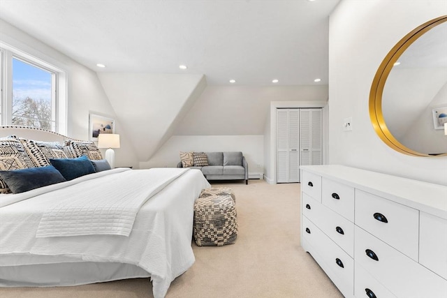 bedroom with lofted ceiling, light carpet, baseboard heating, and a closet