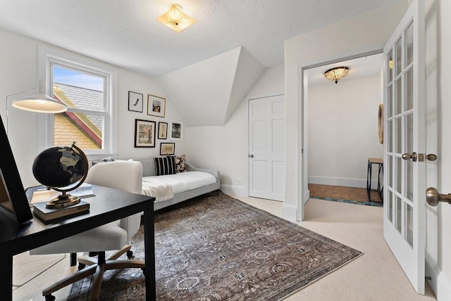 office with lofted ceiling, carpet flooring, and french doors