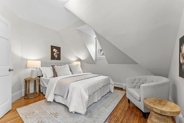 bedroom featuring a baseboard radiator, vaulted ceiling, and hardwood / wood-style floors