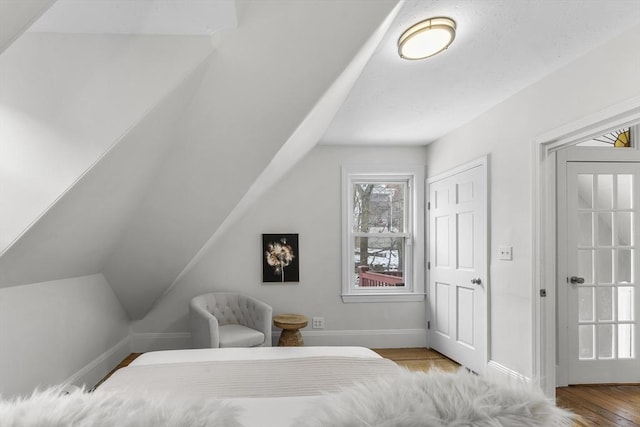 bedroom with vaulted ceiling and light wood-type flooring