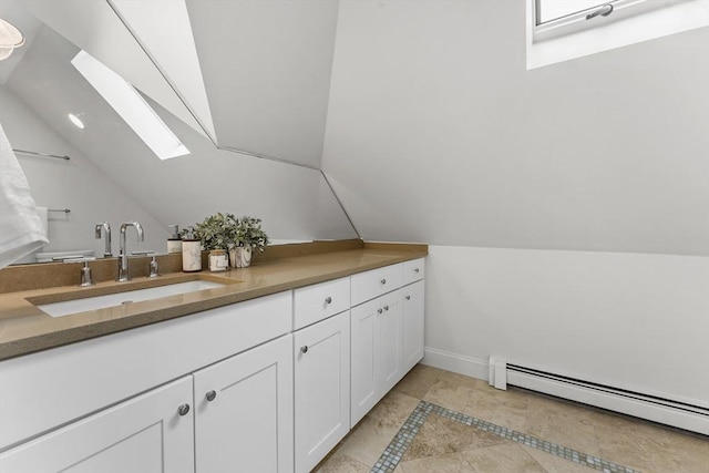 bathroom featuring vanity, a baseboard heating unit, and vaulted ceiling with skylight