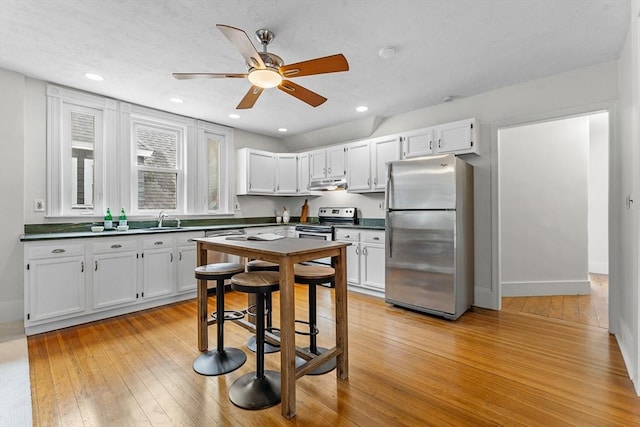 kitchen featuring sink, ceiling fan, white cabinetry, stainless steel appliances, and light hardwood / wood-style floors