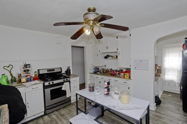 320 Oakland St, Springfield, MA 01108 - kitchen featuring stainless steel range with gas cooktop, light wood finished floors, light countertops, white cabinetry, and arched walkways