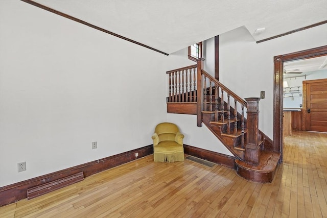 stairway featuring hardwood / wood-style floors and baseboards