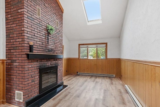 25 Ocallaghan Way, Lynn, MA 01905 - unfurnished living room featuring baseboard heating, vaulted ceiling, wainscoting, a brick fireplace, and a skylight