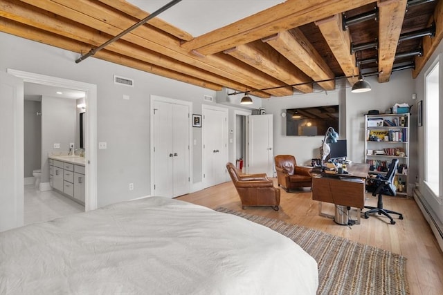 33 Commercial Wharf Unit 33A, Boston, MA 02110 - bedroom featuring a desk, light wood-style floors, baseboard heating, a sink, and connected bathroom