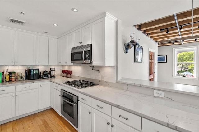 33 Commercial Wharf Unit 33A, Boston, MA 02110 - kitchen featuring appliances with stainless steel finishes, white cabinets, tasteful backsplash, light wood-type flooring, and recessed lighting