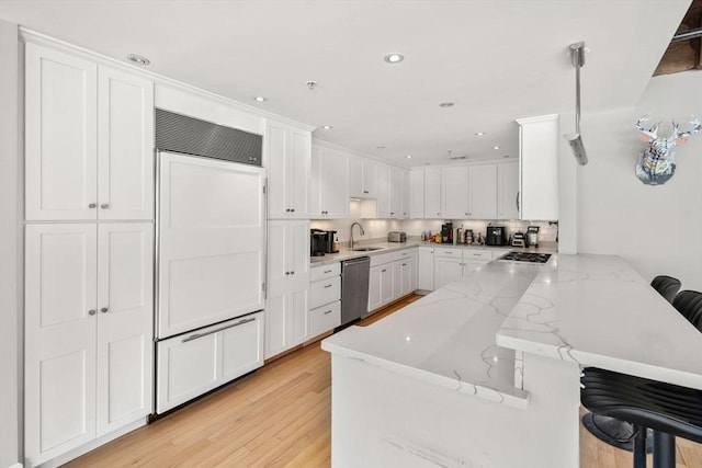 33 Commercial Wharf Unit 33A, Boston, MA 02110 - kitchen with appliances with stainless steel finishes, a peninsula, a sink, a breakfast bar area, and white cabinets
