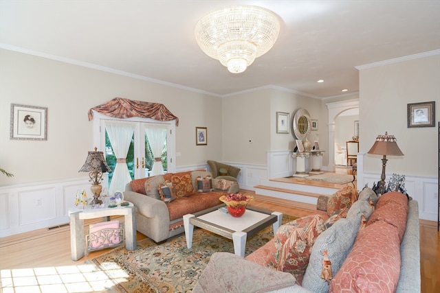 living room with ornamental molding, light hardwood / wood-style flooring, and an inviting chandelier