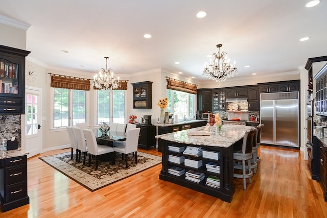 kitchen with a center island, built in fridge, light hardwood / wood-style flooring, and a chandelier