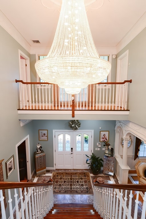 interior space with ornamental molding, wood-type flooring, and an inviting chandelier