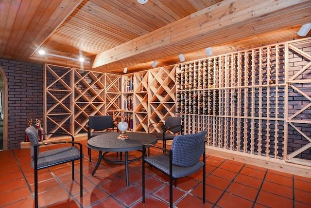 wine cellar featuring tile patterned flooring, brick wall, and wooden ceiling