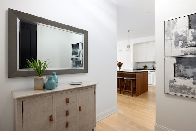 hallway featuring sink and light hardwood / wood-style floors