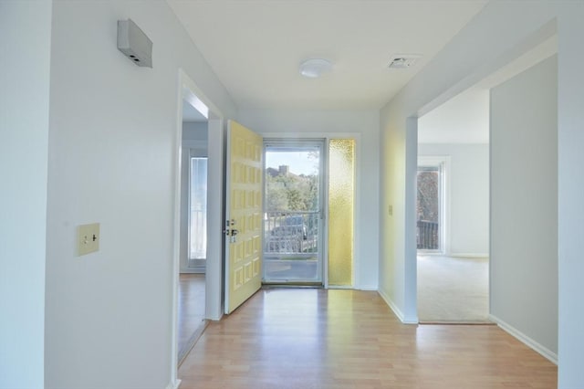 hallway with light hardwood / wood-style floors