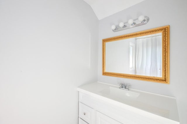 bathroom with vanity and lofted ceiling