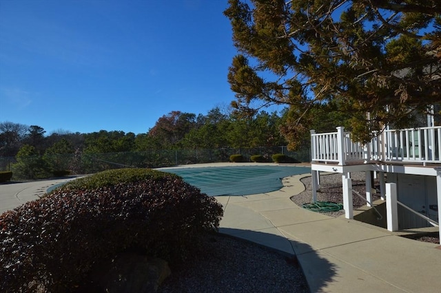 view of swimming pool featuring a patio and a deck