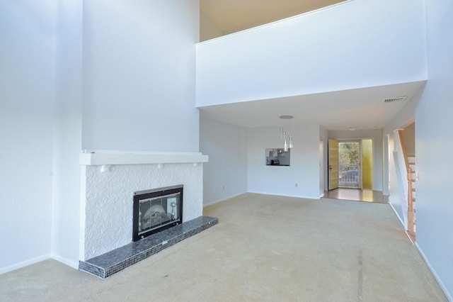 unfurnished living room featuring carpet floors and a high ceiling