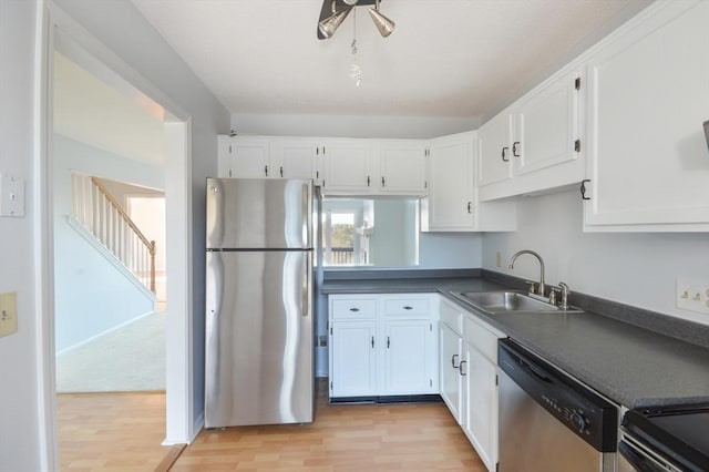 kitchen featuring sink, white cabinets, stainless steel appliances, and light hardwood / wood-style floors