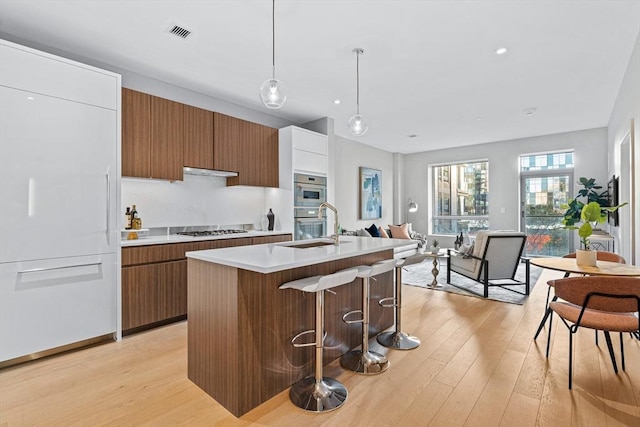 kitchen with visible vents, modern cabinets, light countertops, gas cooktop, and a sink