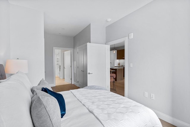 bedroom featuring light wood finished floors and baseboards