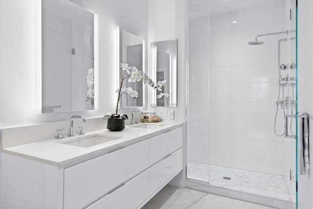 bathroom with tiled shower, a sink, and double vanity