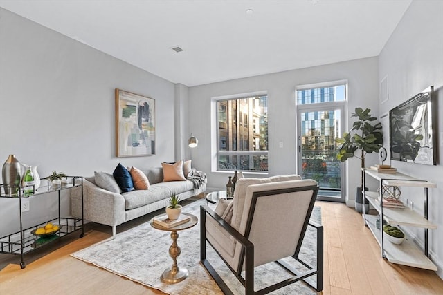 living room featuring light wood-type flooring and visible vents