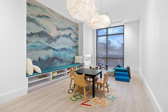 dining room with baseboards, wood finished floors, floor to ceiling windows, a notable chandelier, and recessed lighting