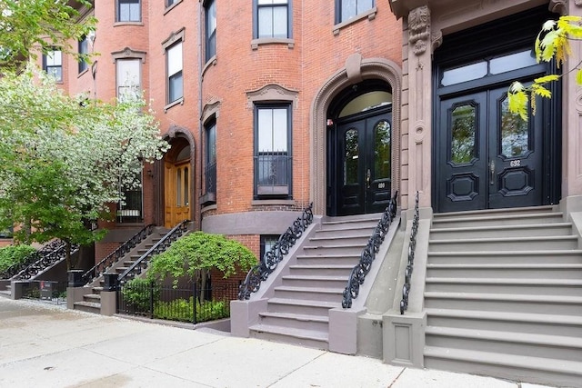 view of exterior entry with french doors and brick siding