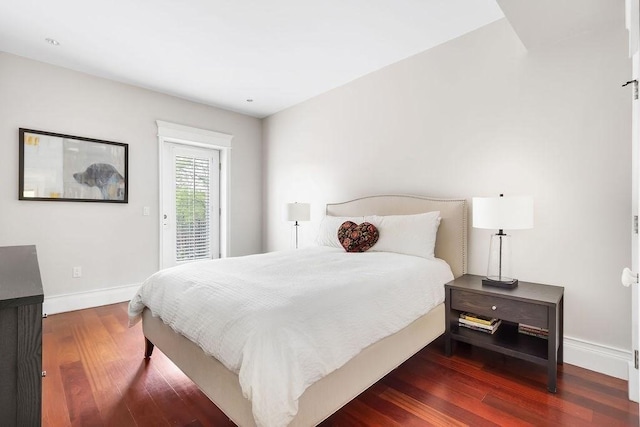 bedroom with wood finished floors, baseboards, and access to outside