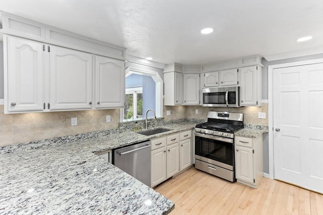3 Centennial Dr, Blackstone, MA 01504 - kitchen with light stone counters, a sink, light wood finished floors, stainless steel appliances, and backsplash