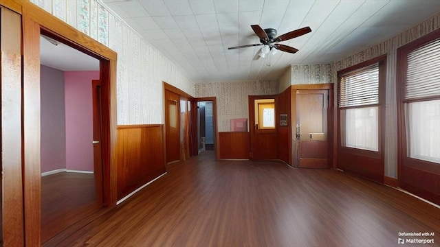 entryway with ceiling fan, wood finished floors, wainscoting, and wallpapered walls