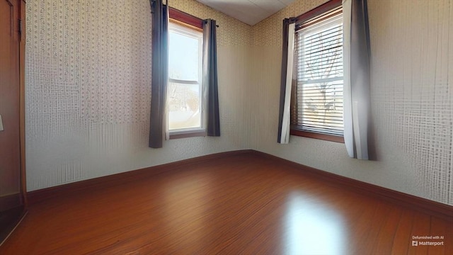 spare room featuring wood finished floors and baseboards