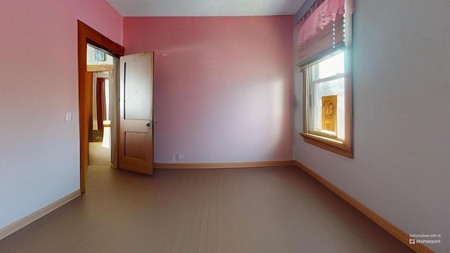 spare room with lofted ceiling, baseboards, and wood finished floors