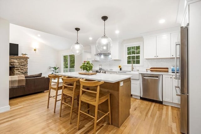 98 Old Forge Rd, Scituate, MA 02066 - kitchen featuring appliances with stainless steel finishes, white cabinets, light wood-style flooring, light countertops, and tasteful backsplash