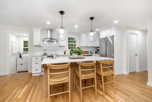 98 Old Forge Rd, Scituate, MA 02066 - kitchen featuring wall chimney range hood, stainless steel appliances, light countertops, decorative backsplash, and white cabinetry