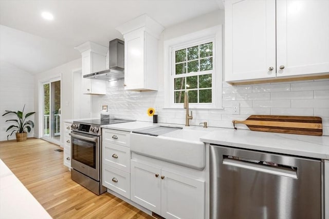 98 Old Forge Rd, Scituate, MA 02066 - kitchen featuring appliances with stainless steel finishes, wall chimney exhaust hood, light wood-style flooring, white cabinetry, and lofted ceiling