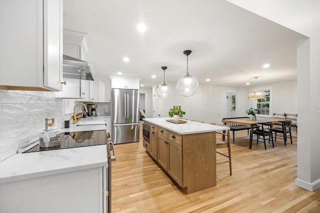 98 Old Forge Rd, Scituate, MA 02066 - kitchen featuring stainless steel fridge, a kitchen bar, tasteful backsplash, light wood finished floors, and recessed lighting