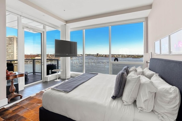 bedroom with access to exterior, dark hardwood / wood-style floors, and multiple windows