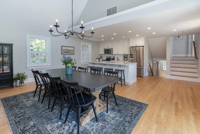28 Marthas Rd, Edgartown, MA 02539 - dining room with light wood-style flooring, a chandelier, lofted ceiling, recessed lighting, and stairs